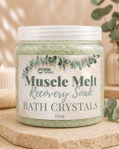 Jar of Muscle Melt Recovery Soak Bath Crystals on a wooden surface with eucalyptus leaves.